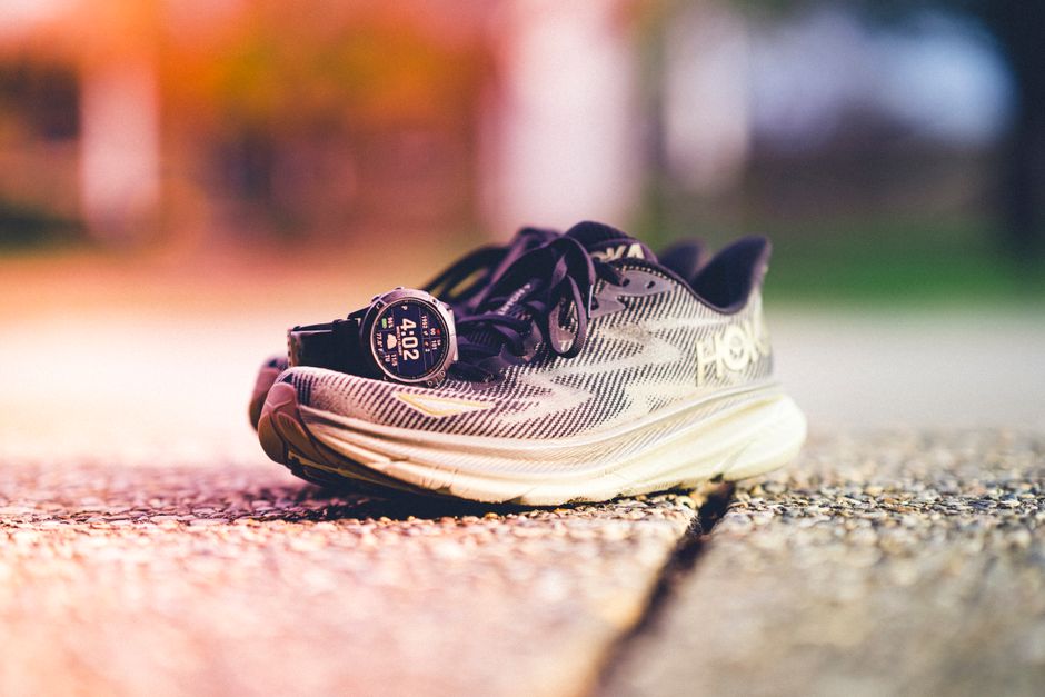 Running shoes with a Garmin-style smartwatch on a sunny day