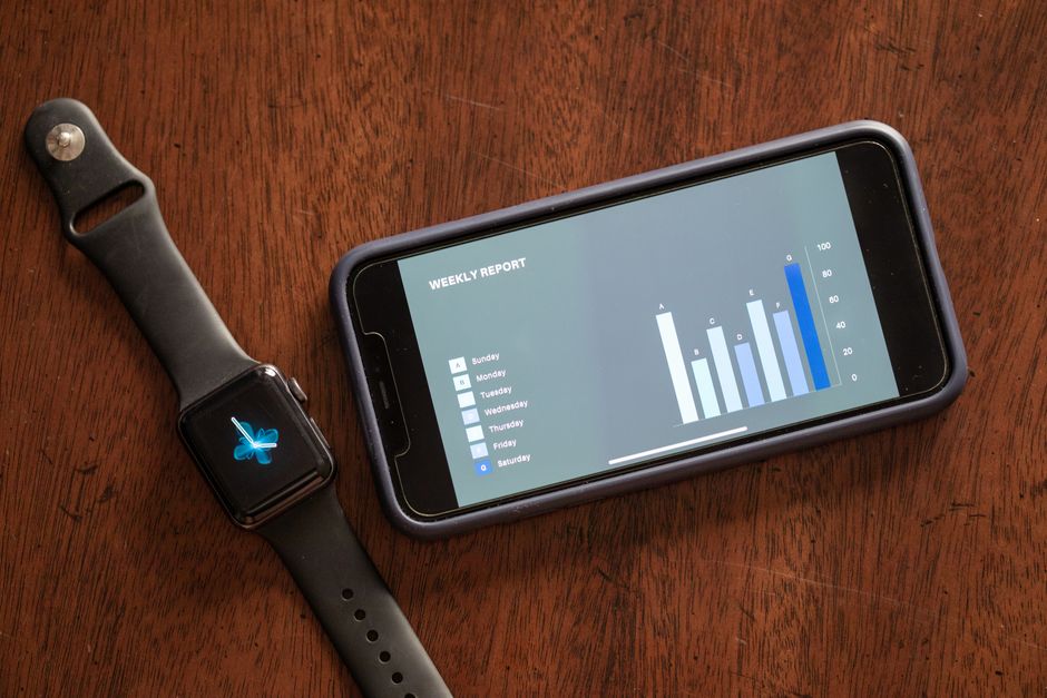A smartphone and smartwatch on a table showing a nutrition tracking app